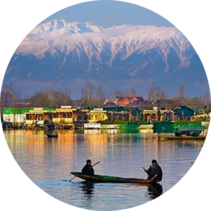 Shikara floating on Dal Lake with snow-capped Himalayan peaks in the background.