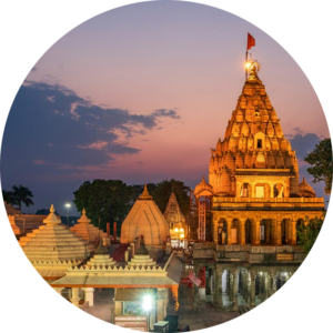 Illuminated Omkareshwar temple at dusk with intricate temple architecture and peaceful surroundings.